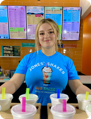 Jones Shakes team member with four milkshakes on the counter